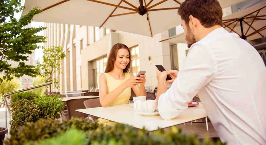 People in cafe gazing on phone screen